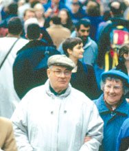 Photo of a crowd scene with an elderly couple in focus at the front